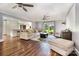 Bright living room featuring an oversized sectional, ceiling fans, and wood flooring overlooking the manicured backyard at 6040 Morris Farm Ln, Mint Hill, NC 28227