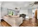 Inviting living room features wood floors, ceiling fans, projector, and access to kitchen through the doorway at 6040 Morris Farm Ln, Mint Hill, NC 28227