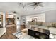 Open-concept living room with brick fireplace, ceiling fans, and seamless flow into the modern kitchen at 6040 Morris Farm Ln, Mint Hill, NC 28227