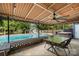 Covered patio with a view of a sparkling pool, hot tub, and pool house at 6040 Morris Farm Ln, Mint Hill, NC 28227