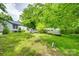 A large backyard with mature trees, a utility shed, a truck and a vintage travel trailer at 622 Neelys Creek Rd, Rock Hill, SC 29732
