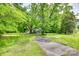 A front yard of a home with large mature trees and a long cracked driveway at 622 Neelys Creek Rd, Rock Hill, SC 29732
