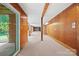 Unfinished basement with wood paneling, exposed beams, and a walk-out door at 7103 Forest Ridge Rd, Matthews, NC 28104