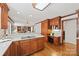 Charming kitchen boasts hardwood floors, wooden cabinets, and a view to the living room at 7103 Forest Ridge Rd, Matthews, NC 28104