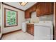 Bright laundry room equipped with washer, dryer, and storage cabinets at 7103 Forest Ridge Rd, Matthews, NC 28104