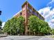 Brick condo building featuring expansive windows and lush trees on a bright day at 715 N Church St # 213, Charlotte, NC 28202