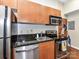 This kitchen has stainless steel appliances, wood cabinets, and granite countertops at 715 N Church St # 213, Charlotte, NC 28202
