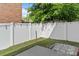 Backyard with lawn, pavers, a white fence and string lights creating a cozy outdoor space at 7341 Adare Mews Rd, Charlotte, NC 28217
