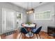 Bright dining area with a modern light fixture, round white table and four blue chairs at 7341 Adare Mews Rd, Charlotte, NC 28217