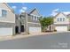 Well-maintained townhome featuring a two-car garage, stone accents, and a manicured lawn at 7341 Adare Mews Rd, Charlotte, NC 28217