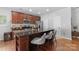 A kitchen island with bar stools, stainless steel appliances, and dark cabinets at 7341 Adare Mews Rd, Charlotte, NC 28217
