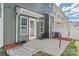 Concrete patio with back entrance to home, trimmed with landscaping and white fence at 7341 Adare Mews Rd, Charlotte, NC 28217