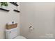 Toilet in the powder room with overhead shelving at 7341 Adare Mews Rd, Charlotte, NC 28217