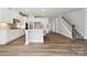 Spacious kitchen with hardwood floors, an island, stainless steel appliances, and an open staircase at 9948 Manor Vista Trl, Kannapolis, NC 28027