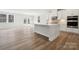Modern kitchen with white cabinets, a large island, stainless steel appliances, and hardwood flooring at 9948 Manor Vista Trl, Kannapolis, NC 28027