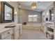 Elegant bathroom with dual vanities, a soaking tub, stylish black and white tiled floor, and modern lighting at 1020 Forbishire Dr, Matthews, NC 28104