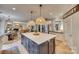 Bright kitchen with white quartz countertops, a navy blue island, and woven light fixtures at 1020 Forbishire Dr, Matthews, NC 28104