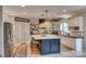 Charming kitchen with white cabinets, a navy blue kitchen island, and modern woven light fixtures at 1020 Forbishire Dr, Matthews, NC 28104