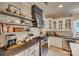 White kitchen with stainless steel appliances, decorative shelving, and black countertops at 1020 Forbishire Dr, Matthews, NC 28104
