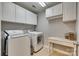 Functional laundry room with white cabinets, modern washer and dryer, and folding table at 1020 Forbishire Dr, Matthews, NC 28104