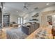 Bright living room featuring a gray sofa, large rug, hardwood floors, and built-in shelving with sports memorabilia at 1020 Forbishire Dr, Matthews, NC 28104
