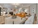 Spacious living room with a decorative fireplace, an orange couch, and neutral-toned furniture at 1020 Forbishire Dr, Matthews, NC 28104