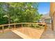 Large wooden deck with black metal railing overlooking a private backyard with mature trees and lush greenery at 104 Whiterock Dr, Mount Holly, NC 28120