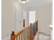 Upstairs hallway with wooden railing, leading to bedrooms and bathrooms, bright and inviting at 104 Whiterock Dr, Mount Holly, NC 28120