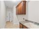 Functional laundry room with tile flooring, granite countertop, sink, and wooden cabinets above at 104 Whiterock Dr, Mount Holly, NC 28120