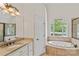 Spa-like primary bath with granite counters, soaking tub, and custom lighting at 104 Whiterock Dr, Mount Holly, NC 28120