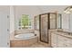 Primary bathroom with a soaking tub, glass shower, and dual sink vanity at 104 Whiterock Dr, Mount Holly, NC 28120