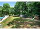 Spacious backyard featuring a play area, shed, lush lawn, and mature trees at 105 Chippewa Trl, China Grove, NC 28023