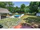 Beautifully landscaped backyard with an in-ground pool, outdoor seating, stone patio and mature trees at 105 Chippewa Trl, China Grove, NC 28023