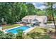 Aerial view of a beautiful backyard with a sparkling pool, patio, outdoor kitchen, and play area at 105 Chippewa Trl, China Grove, NC 28023