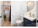 Small bathroom featuring dark blue vanity, faucet, modern wallpaper, and toilet at 105 Chippewa Trl, China Grove, NC 28023