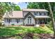 Charming two-story home featuring a stone accent facade, inviting front porch, and a well-manicured lawn with mature trees at 105 Chippewa Trl, China Grove, NC 28023