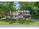 Beautiful two-story home surrounded by mature trees, featuring a stone facade, shutters, and a well-kept lawn at 105 Chippewa Trl, China Grove, NC 28023
