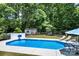 Beautiful in-ground pool surrounded by lush greenery with plenty of room for lounge chairs and other outdoor features at 105 Chippewa Trl, China Grove, NC 28023