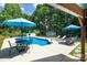 Backyard pool area with comfortable lounge chairs, an outdoor dining set, and mature trees at 105 Chippewa Trl, China Grove, NC 28023