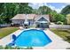 A refreshing in-ground pool highlights the property's outdoor space, complemented by a lounge area and mature trees at 105 Chippewa Trl, China Grove, NC 28023