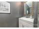 Modern half-bathroom with gray walls, a decorative mirror, and white sink at 10617 Fuller Ridge Cir, Charlotte, NC 28270
