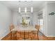 Bright dining room with stylish light fixtures, wood table, and views of the backyard at 10617 Fuller Ridge Cir, Charlotte, NC 28270