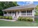 Welcoming home with a covered front porch, complemented by mature landscaping and green grass at 113 Marina Ln, Mooresville, NC 28117