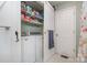 A bright laundry room features a white washer and dryer, wire shelving, and essential laundry supplies at 113 Marina Ln, Mooresville, NC 28117