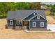 Charming single-story home with blue siding, stone foundation, well-manicured lawn, and a welcoming front porch providing curb appeal at 115 Falling Creek Dr, Statesville, NC 28625