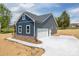 A detached garage with a concrete driveway provides ample parking with beautiful landscaping around the property at 115 Falling Creek Dr, Statesville, NC 28625