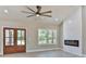 Well-lit living room features a large ceiling fan, fireplace, and views of the outdoors at 115 Falling Creek Dr, Statesville, NC 28625