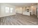Bright, open-concept living space with modern gray wood flooring, large windows, and adjacent kitchen at 1223 Morehead Dr, Salisbury, NC 28144