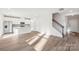 Bright open-concept living area with light wood floors adjacent to a modern kitchen and staircase at 125 Canoga Ave, York, SC 29745