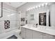 A bright bathroom with a double vanity, tiled shower, and clean design, offering a refreshing and stylish space at 127 N Tryon St # 404, Charlotte, NC 28202